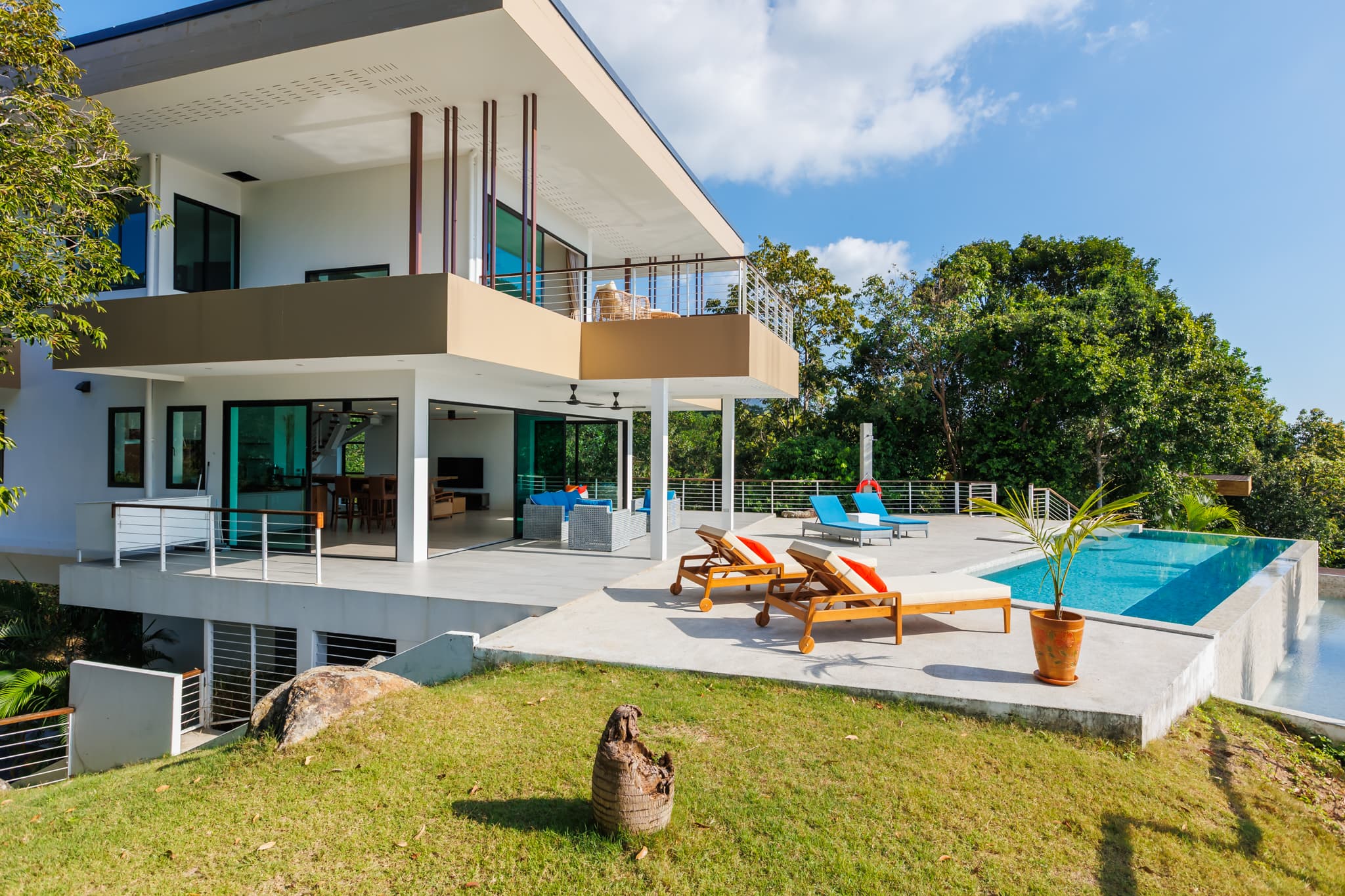 Außenansicht der Villa mit Infinity-Pool, Terrasse und Rasen