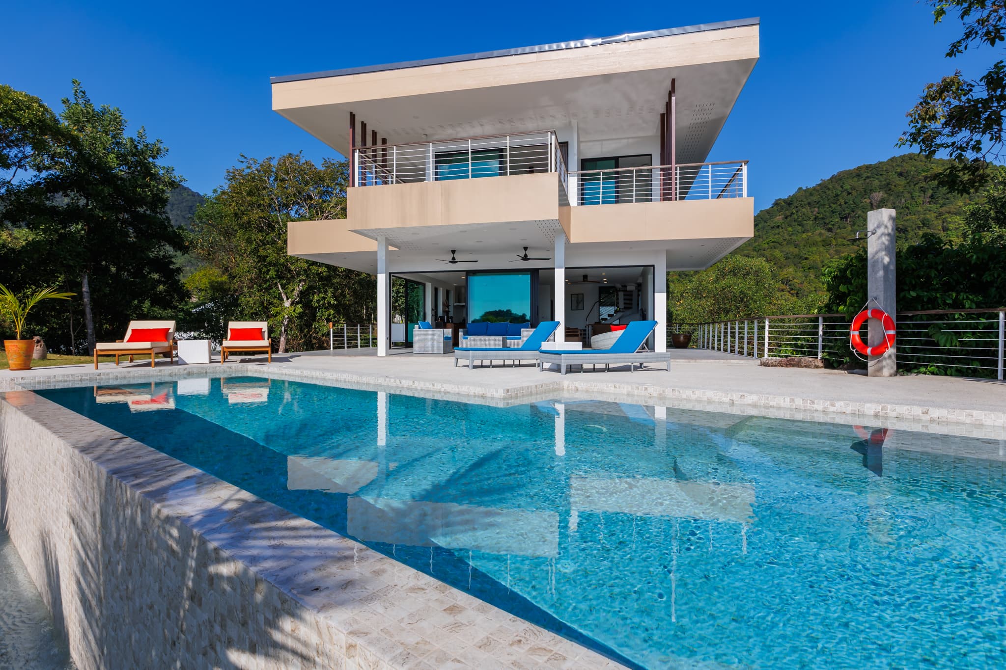 Infinity-Pool mit Blick auf die Villa und grüne Hügel